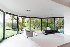 a living room with a lot of windows at Hahndorf Farm Barn in Hahndorf