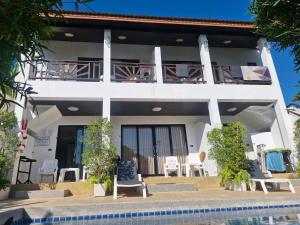 a white house with chairs and a swimming pool at BEA Privileged Apartment in Lamai