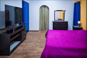 a bedroom with a bed and a dresser and a mirror at La casa azul en Ticul Yucatán in Ticul