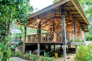 ein großes Holzhaus mit Treppe in einem Garten in der Unterkunft คีรีเขาสกริเวอร์ in Khao Sok
