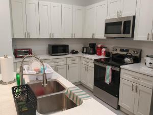eine Küche mit weißen Schränken und einer Spüle in der Unterkunft Beautiful Room in quiet place shared bath in Ocala