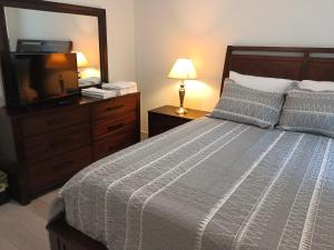 ein Schlafzimmer mit einem Bett und einer Kommode mit Spiegel in der Unterkunft Beautiful Room in quiet place shared bath in Ocala