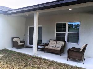 eine Veranda mit zwei Stühlen und zwei Fenstern in der Unterkunft Beautiful Room in quiet place shared bath in Ocala