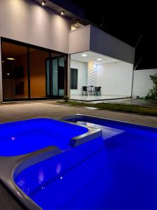 una piscina blu di fronte a una casa di notte di casa com piscina a Sinop