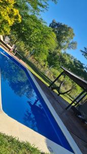 une piscine bleue avec des arbres en arrière-plan dans l'établissement La Nené hospedaje vacacional, à Villars