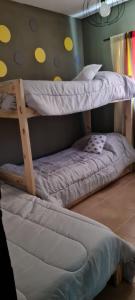 deux lits superposés côte à côte dans une pièce dans l'établissement La Nené hospedaje vacacional, à Villars 13 autres photos