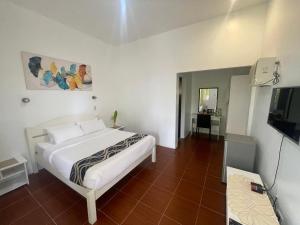 a bedroom with a bed and a television in it at Reef Waters Resort in Pilar