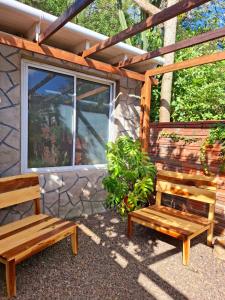 due panche di legno sedute di fronte a un edificio di Dona Monica a Ituzaingó