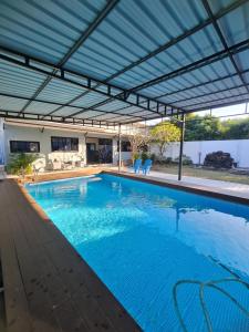een groot zwembad met een dak bij สกลนครพูลวิลล่า in Sakon Nakhon