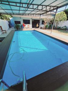 een groot zwembad met blauw water bij สกลนครพูลวิลล่า in Sakon Nakhon