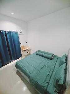 een slaapkamer met een groen bed en blauwe gordijnen bij สกลนครพูลวิลล่า in Sakon Nakhon +18 foto's