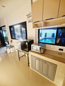 een keuken met een aanrecht met een tv erop bij สกลนครพูลวิลล่า in Sakon Nakhon