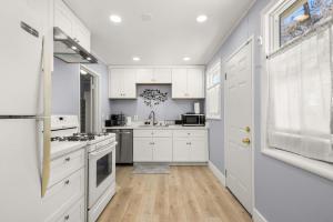 een witte keuken met witte kasten en een houten vloer bij Marbella Lane - Alluring & Spacious 3BR Home in Cambrian Park