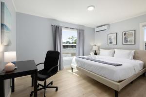 een witte slaapkamer met een bed, een bureau en een raam bij Marbella Lane - Alluring & Spacious 3BR Home in Cambrian Park