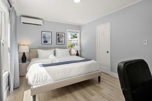 een slaapkamer met een groot wit bed en een stoel bij Marbella Lane - Alluring & Spacious 3BR Home in Cambrian Park