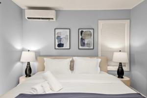 een slaapkamer met een groot wit bed met twee lampen bij Marbella Lane - Alluring & Spacious 3BR Home in Cambrian Park