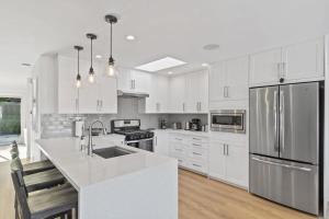 een keuken met witte kasten en een roestvrijstalen koelkast bij Marbella Lane - 3BR w sweeping views of Bay Area in Laurel
