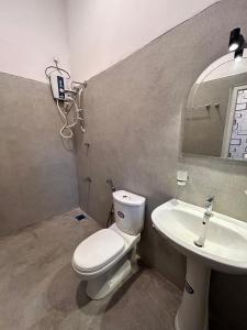 a bathroom with a toilet and a sink at Riverside Serenity in Talpe +10 photos