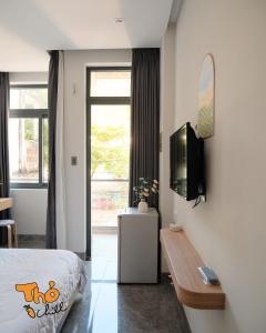 een slaapkamer met een bed en een tv aan de muur bij Thỏ Chill Homestay in Vung Tau