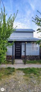 a white house with a gate and a fence at Antün Küyen in Trevelin +6 photos