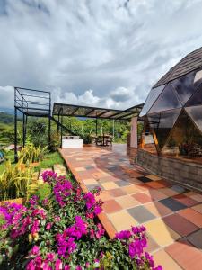 a patio with purple flowers and a glass roof at Prana Hills in Arbeláez +35 photos