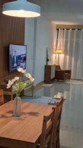 ein Wohnzimmer mit einem Holztisch und einem TV in der Unterkunft บ้านใจฟู URBAN HOMe in Mukdahan