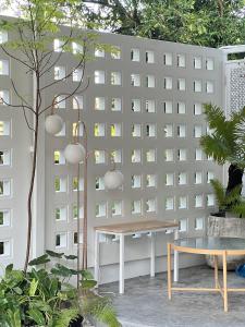 einen weißen Zaun mit einem Tisch und einer Bank in der Unterkunft บ้านใจฟู URBAN HOMe in Mukdahan