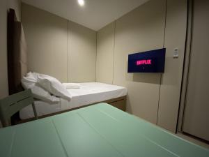 a small room with two beds and a clock on the wall at BuenaSentro Hostel in Manila