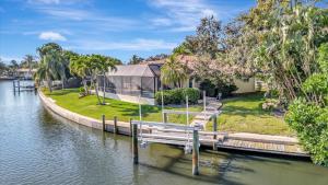 a house with a dock next to a body of water at Siesta Key Beach Waterfront Home with Kayaks and Bikes in Siesta Key