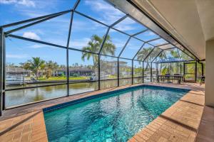 an indoor swimming pool with a glass wall at Siesta Key Beach Waterfront Home with Kayaks and Bikes in Siesta Key