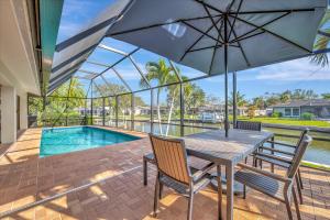 a patio with a table and chairs and a pool at Siesta Key Beach Waterfront Home with Kayaks and Bikes in Siesta Key +26 photos