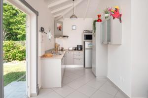 una cucina con mobili bianchi e un piano di lavoro di Les Jardins des Alizés a Saint-François Altre 13 foto