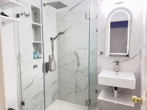 een witte badkamer met een wastafel en een douche bij Feel at home Inn in McKinney