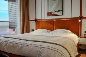 een slaapkamer met een groot bed met een groot raam bij Apartments Akash - Tashkent City Residence in Tasjkent