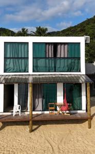 a house on the beach with a deck at Duplex beira mar ilha grande proveta in Angra dos Reis +3 photos