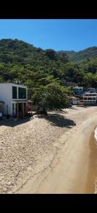 a beach with a building on the side of it at Duplex beira mar ilha grande proveta in Angra dos Reis