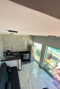 a living room with a kitchen with a stone wall at Duplex beira mar ilha grande proveta in Angra dos Reis