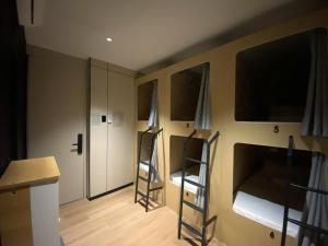a room with three bunk beds and a kitchen at BuenaSentro Hostel in Manila