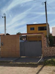 a yellow house with a gate and a fence at Casa Brisa do Mar in Tamandaré
