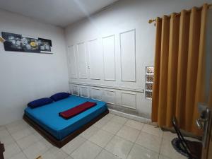 una camera da letto con un letto blu in una stanza di Devania Homestay a Pagaralam