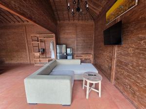 a living room with a couch and a tv at Pradnya Villa in Ubud