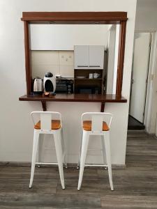 two white chairs sitting at a counter in a kitchen at Apartamento entero 2 Dormitorios in Montevideo