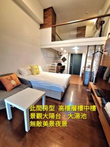 ein Wohnzimmer mit zwei Betten und einer Couch in der Unterkunft Winter湯屋樓中樓 in Jiaoxi