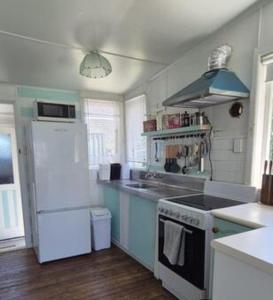 a kitchen with a sink and a stove top oven at Pipi Palace in Papamoa