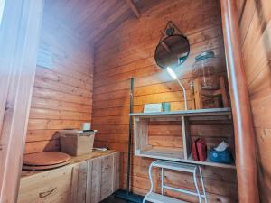 Zimmer mit einer Holzwand mit einem Tisch und einer Lampe in der Unterkunft Cabane perchée en pleine nature, déconnexion à La Pérouille - FR-1-591-772 in La Pérouille