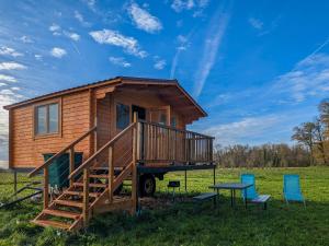 ein winziges Haus mit einer Terrasse und zwei Stühlen in der Unterkunft Cabane perchée en pleine nature, déconnexion à La Pérouille - FR-1-591-772 in La Pérouille