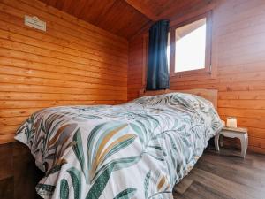 ein Schlafzimmer mit einem Bett in einem Holzzimmer in der Unterkunft Cabane perchée en pleine nature, déconnexion à La Pérouille - FR-1-591-772 in La Pérouille