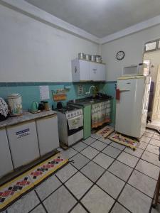 a kitchen with refrigerators and appliances on a tiled floor at Casa quarto dormitório estudantil a 100m da UESC em salobrinho para uescquianos in Ilhéus