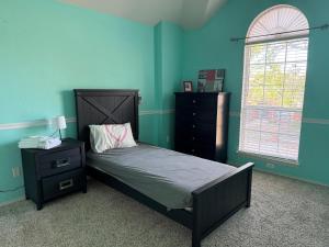 ein Schlafzimmer mit einem Bett, einer Kommode und einem Fenster in der Unterkunft Happy Family Inn in McKinney + 6 Fotos