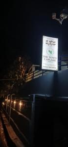 een bord aan de zijkant van een gebouw 's nachts bij The Town Cascade in Madikeri